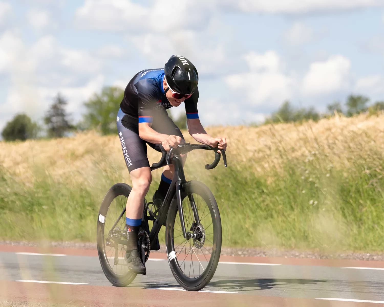 Renner laag op de racefiets, schuin van voren gefotografeerd