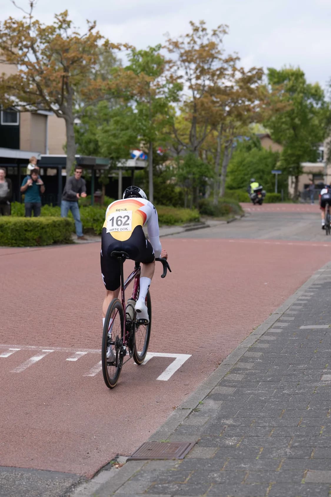 Tijdrijder met rugnummer 162 van achteren, op weg naar de finish